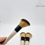 نمای نزدیک از براش آرایشی با دسته سفید و موهای نرم